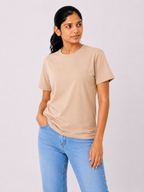 Woman wearing a beige t-shirt and light blue jeans on a plain background