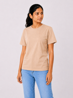 Woman wearing a beige t-shirt and blue jeans on a plain background