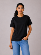 Person wearing a black t-shirt and blue jeans against a gray background