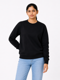 Person wearing a black sweatshirt and light blue jeans on a white background