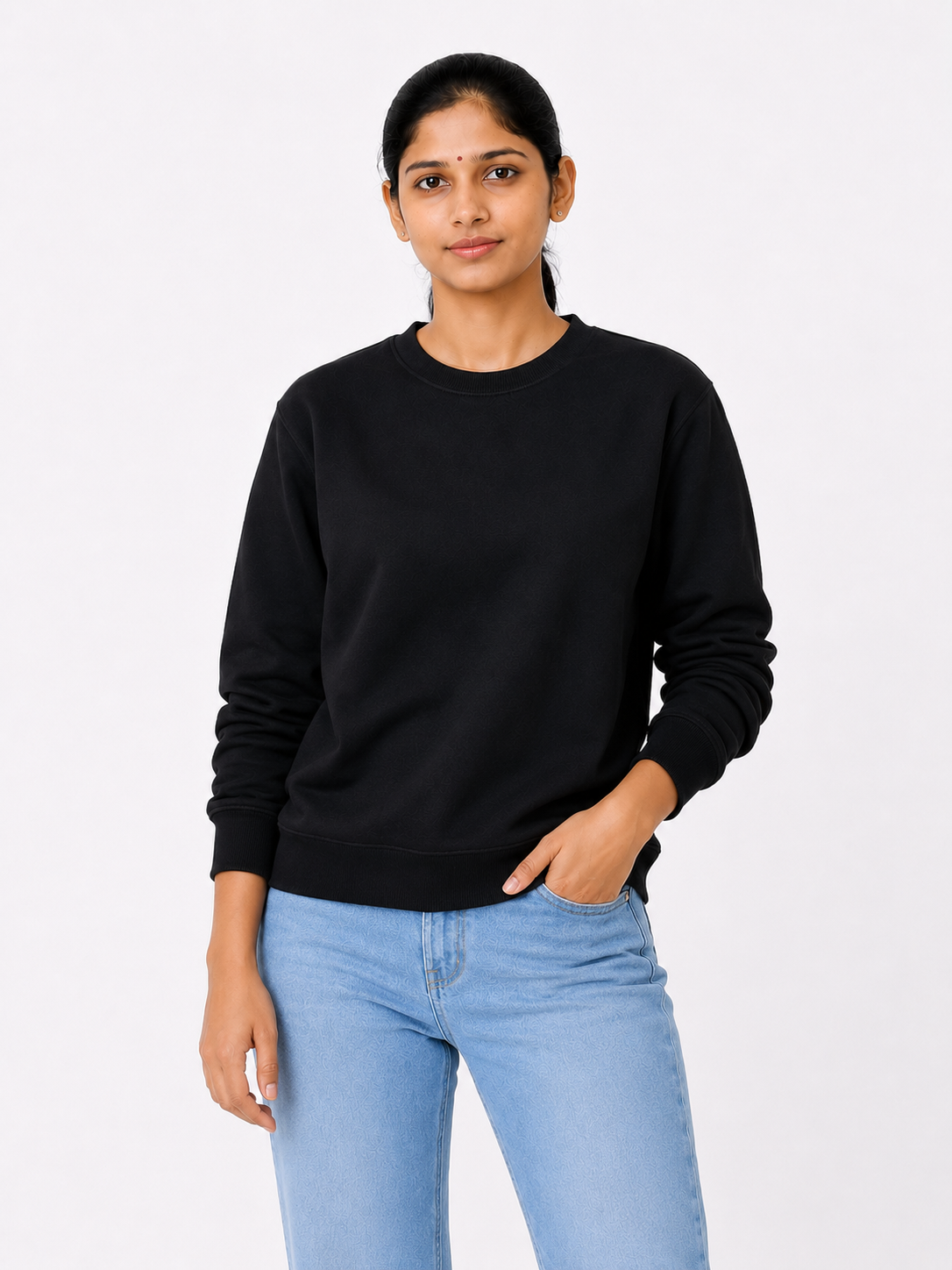Woman wearing a black sweater and light blue jeans on a white background