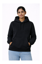 Person wearing a black hoodie and light blue jeans on a white background