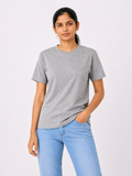 Woman wearing a gray t-shirt and light blue jeans on a white background