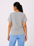 Person wearing a gray t-shirt and blue jeans on a white background