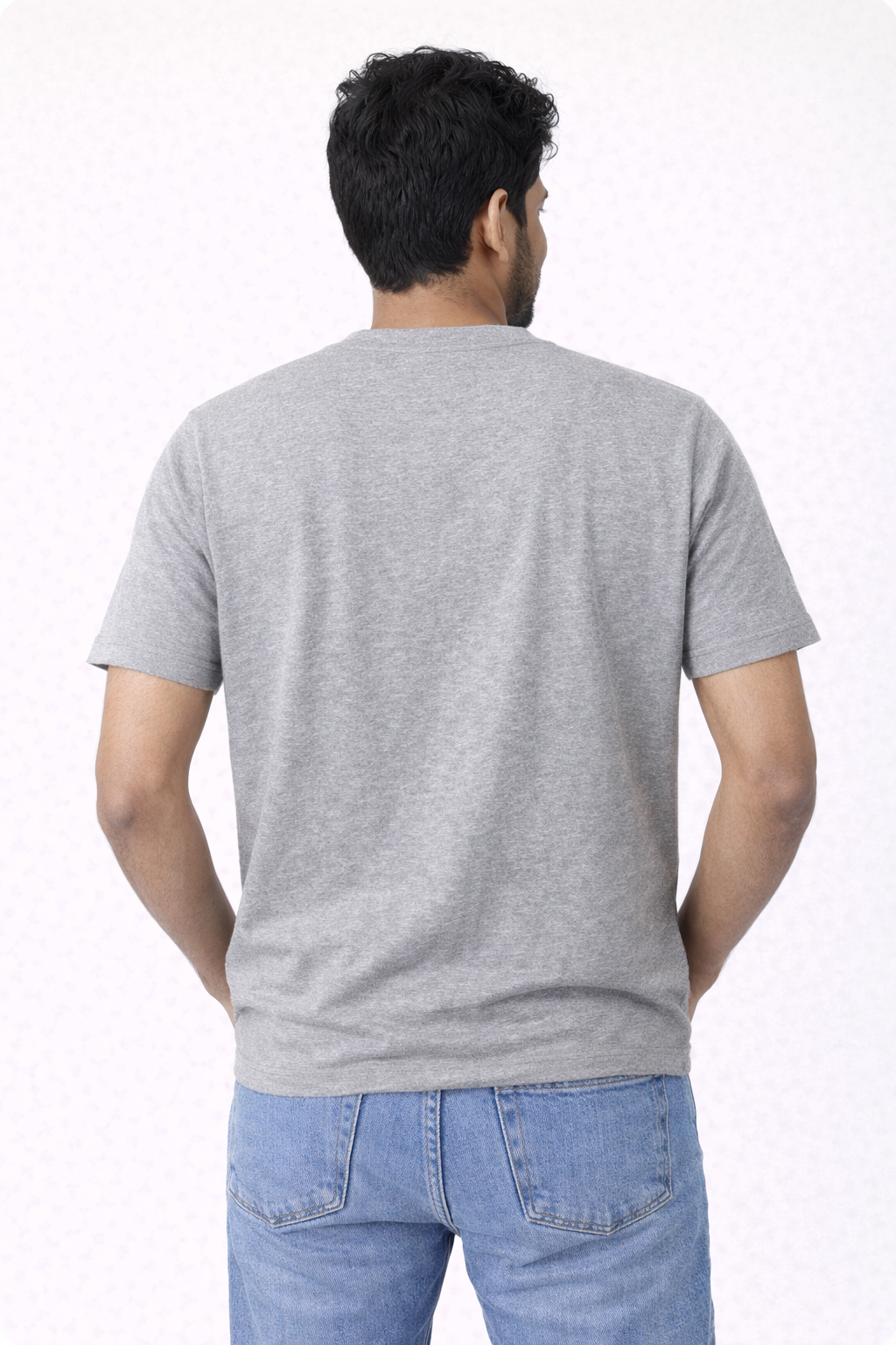 Man wearing a gray t-shirt and blue jeans on a white background