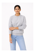 Person wearing a gray sweatshirt and light blue jeans on a white background