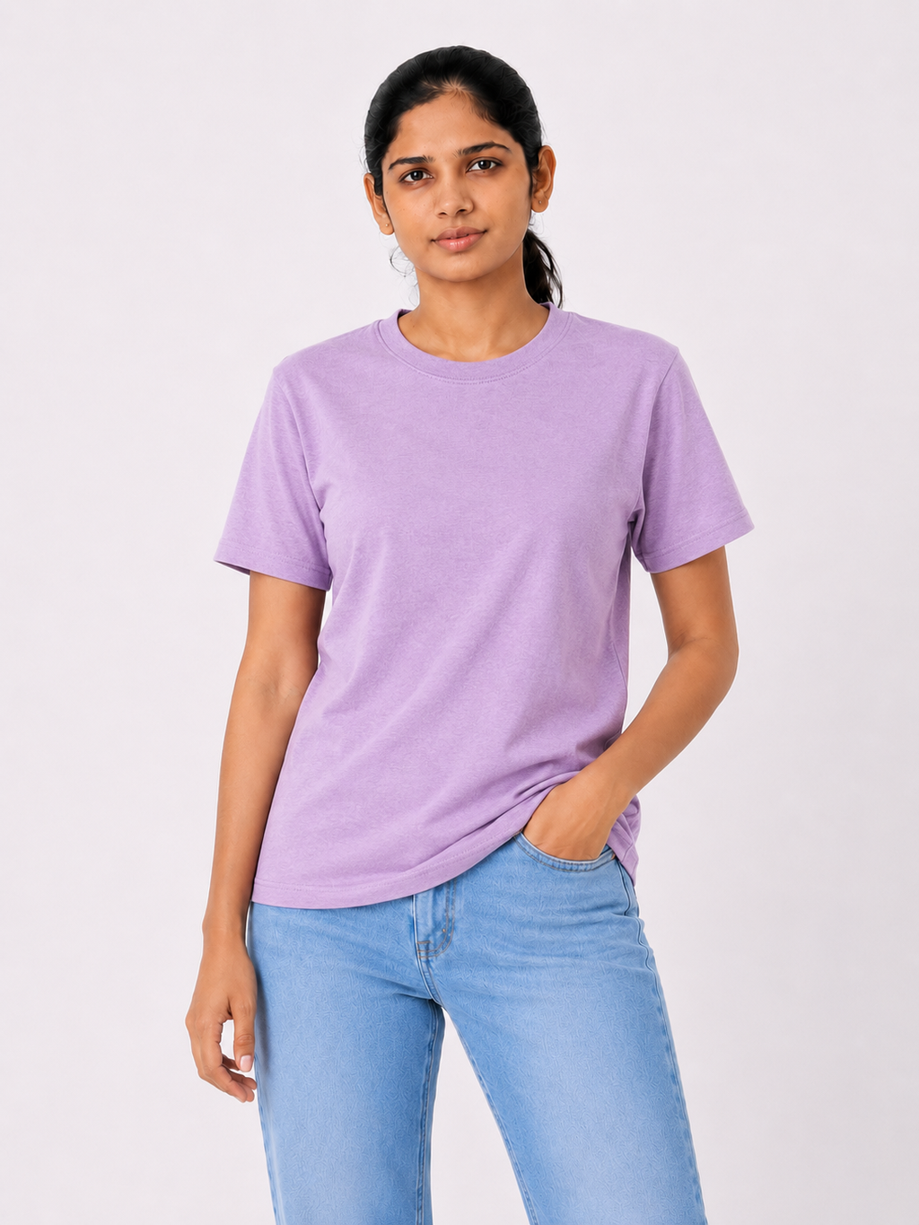 Woman wearing a purple t-shirt and light blue jeans on a white background