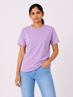 Woman wearing a purple t-shirt and light blue jeans on a white background
