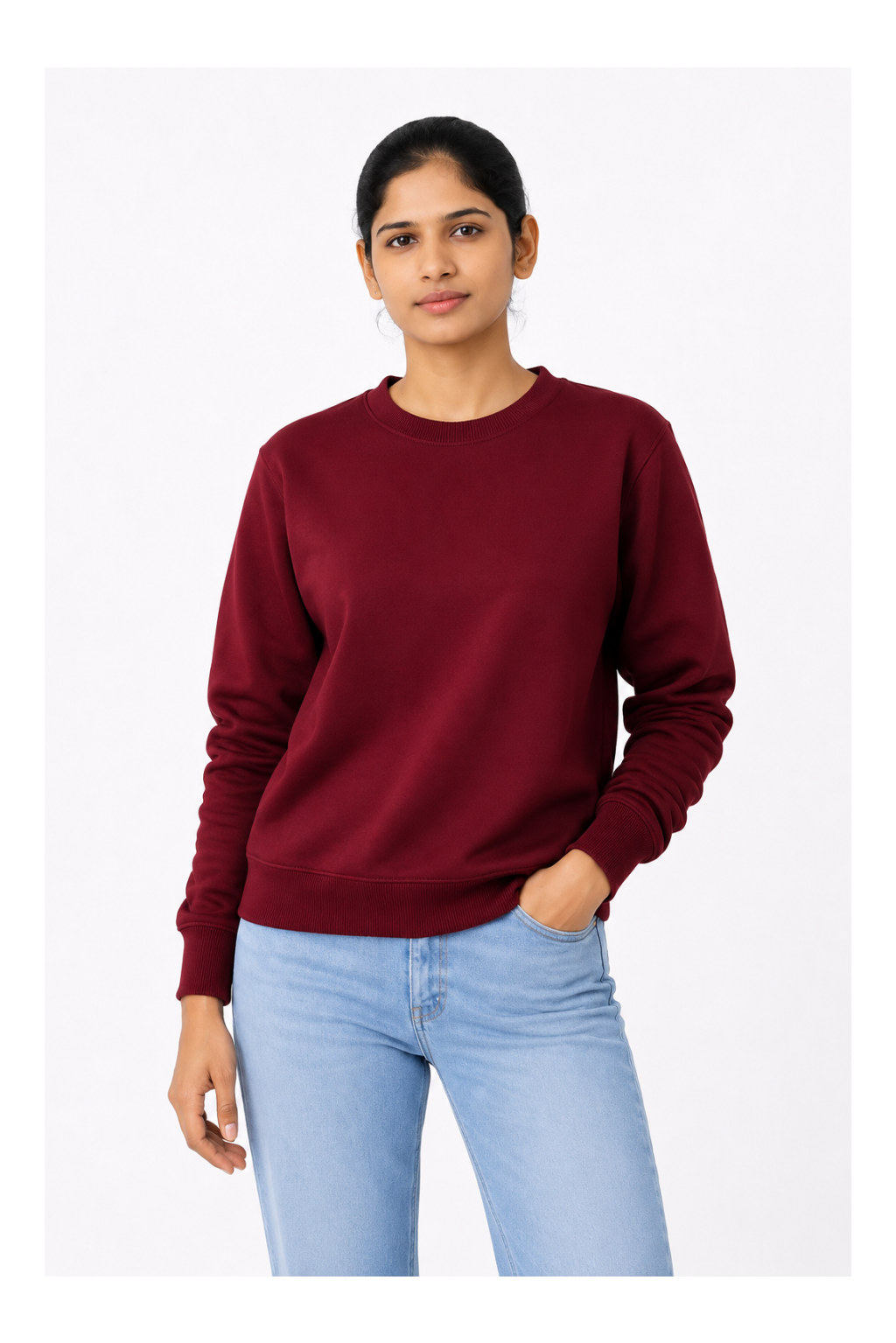Woman wearing a maroon sweatshirt and light blue jeans on a white background