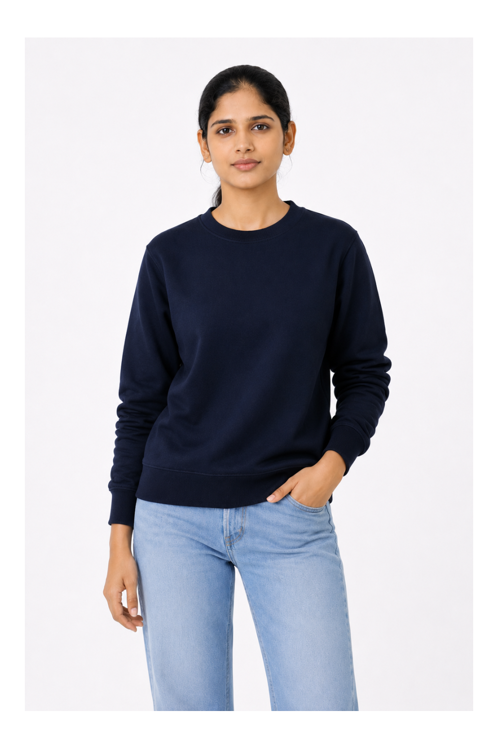 Woman wearing a navy sweater and light blue jeans on a white background