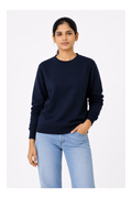 Woman wearing a navy sweater and light blue jeans on a white background