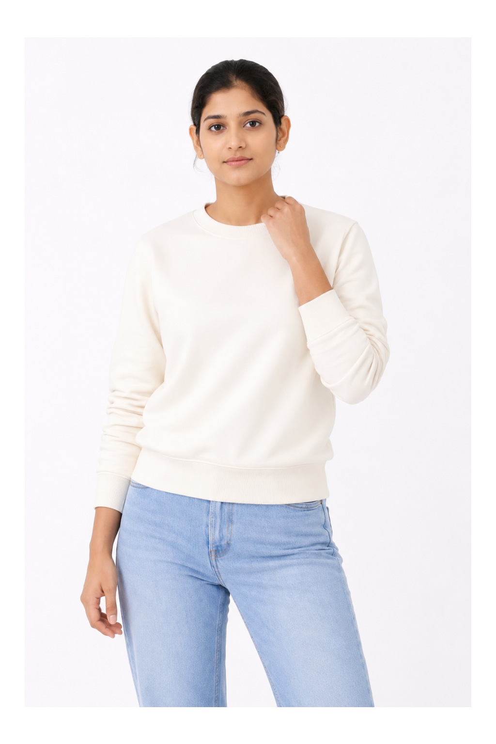 Woman wearing a white sweater and light blue jeans on a white background