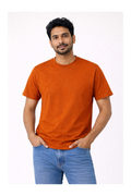 Man wearing an orange t-shirt and blue jeans on a white background
