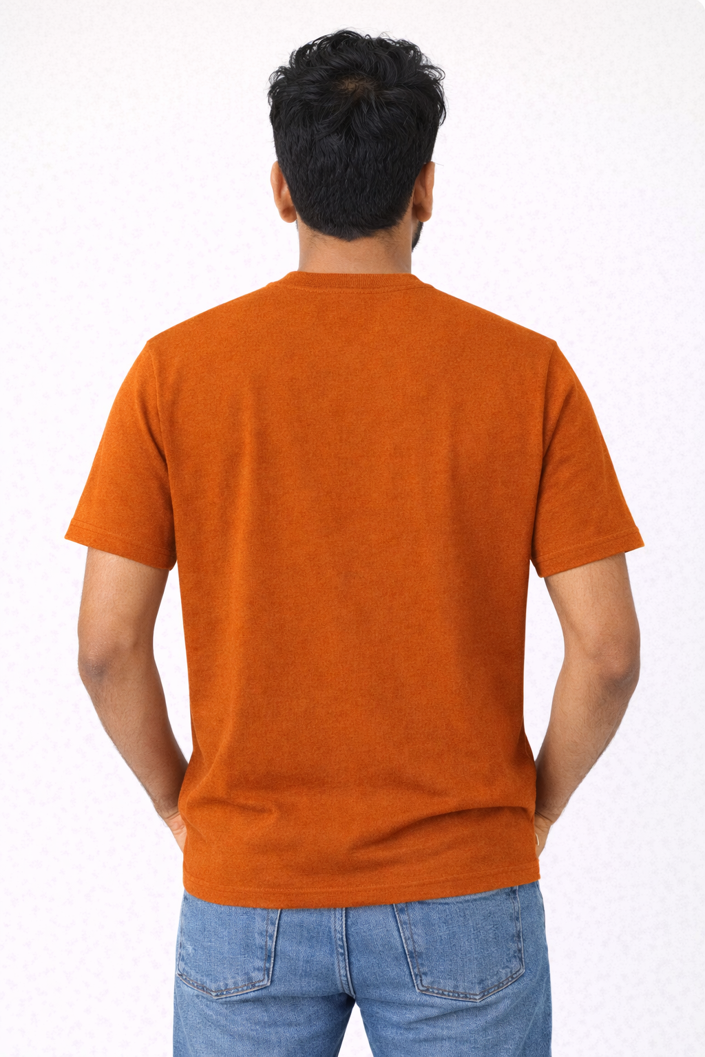 Person wearing an orange t-shirt and blue jeans on a white background
