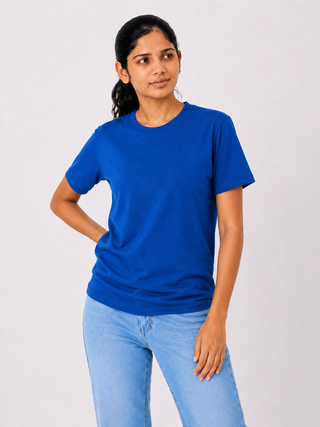 Woman wearing a blue t-shirt and light blue jeans on a white background