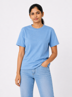 Woman wearing a light blue t-shirt and jeans on a white background