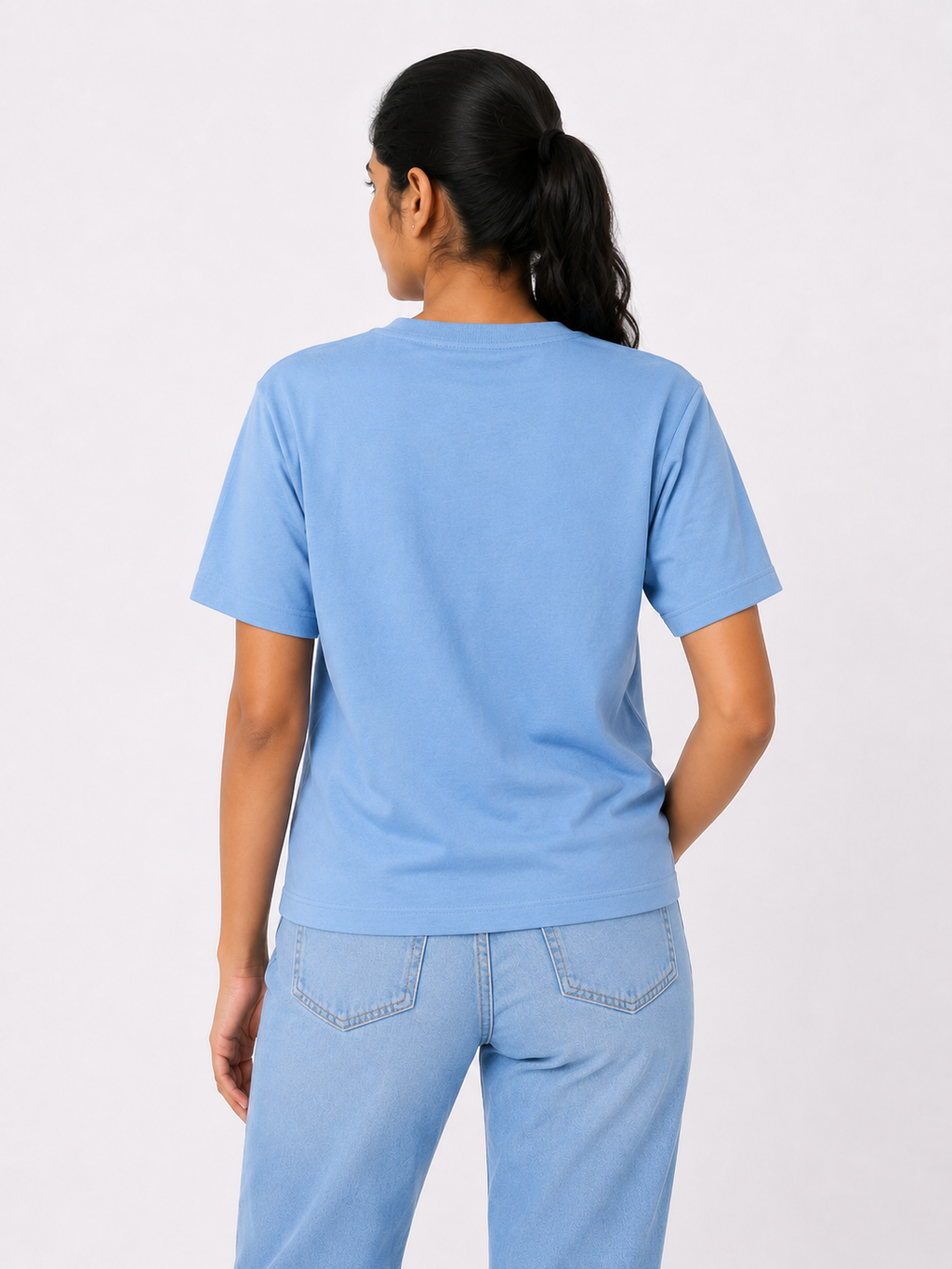 Person wearing a light blue t-shirt and jeans on a white background
