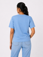 Person wearing a light blue t-shirt and jeans on a white background