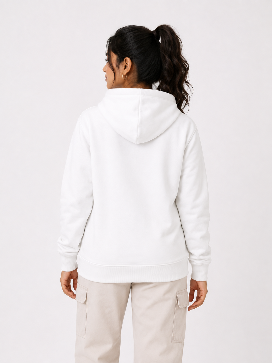 A woman shown from the back wearing a plain white pullover hoodie and light beige cargo pants against a clean white studio background.