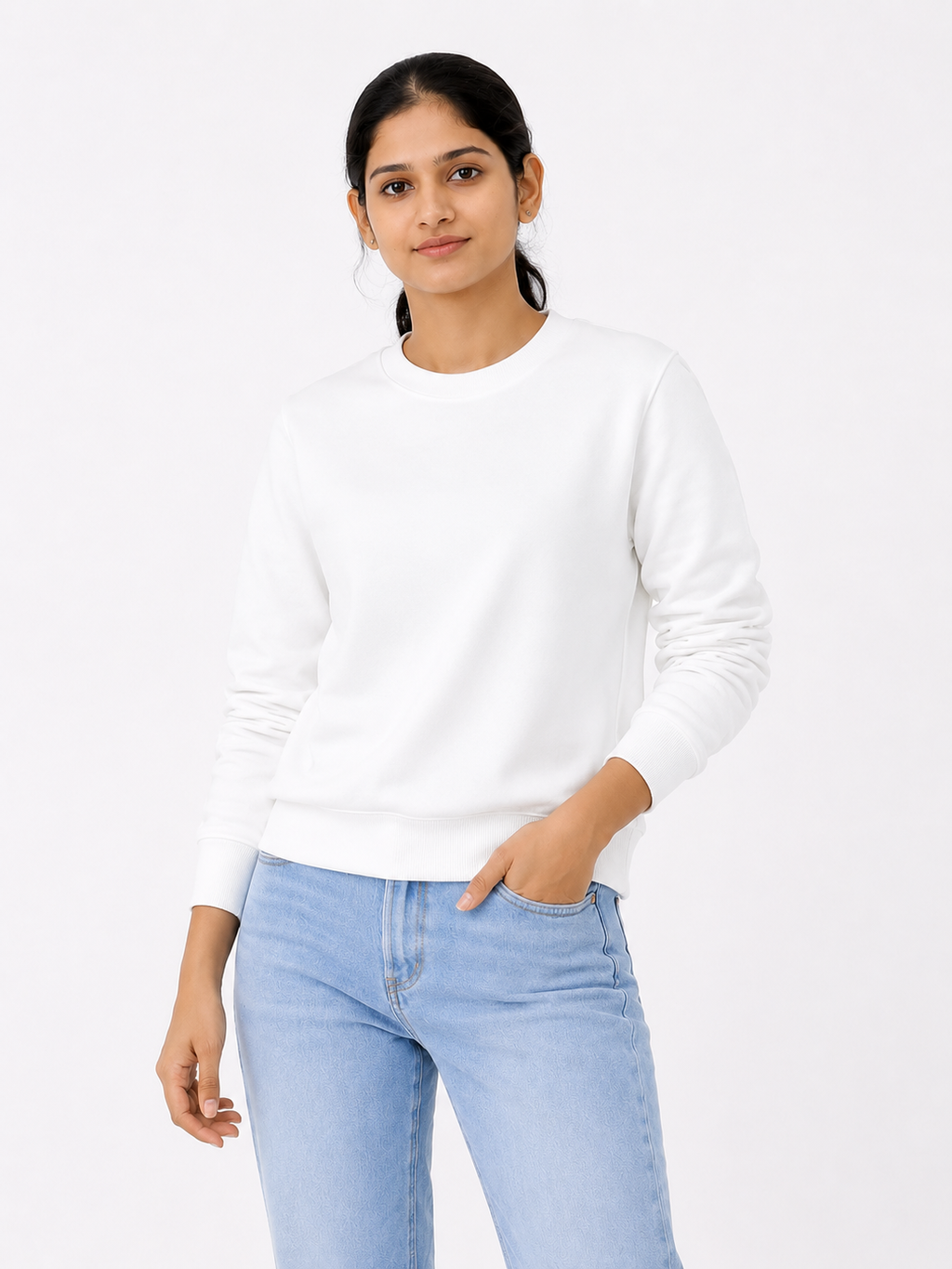 Woman wearing a white sweater and light blue jeans on a white background