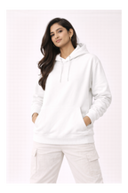 Woman wearing a white hoodie and pants on a light pink background